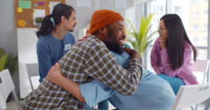 two men embracing during group therapy