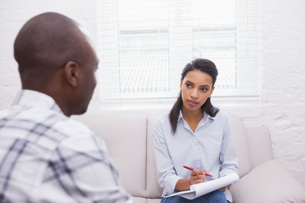 man in individual therapy while his therapist takes notes