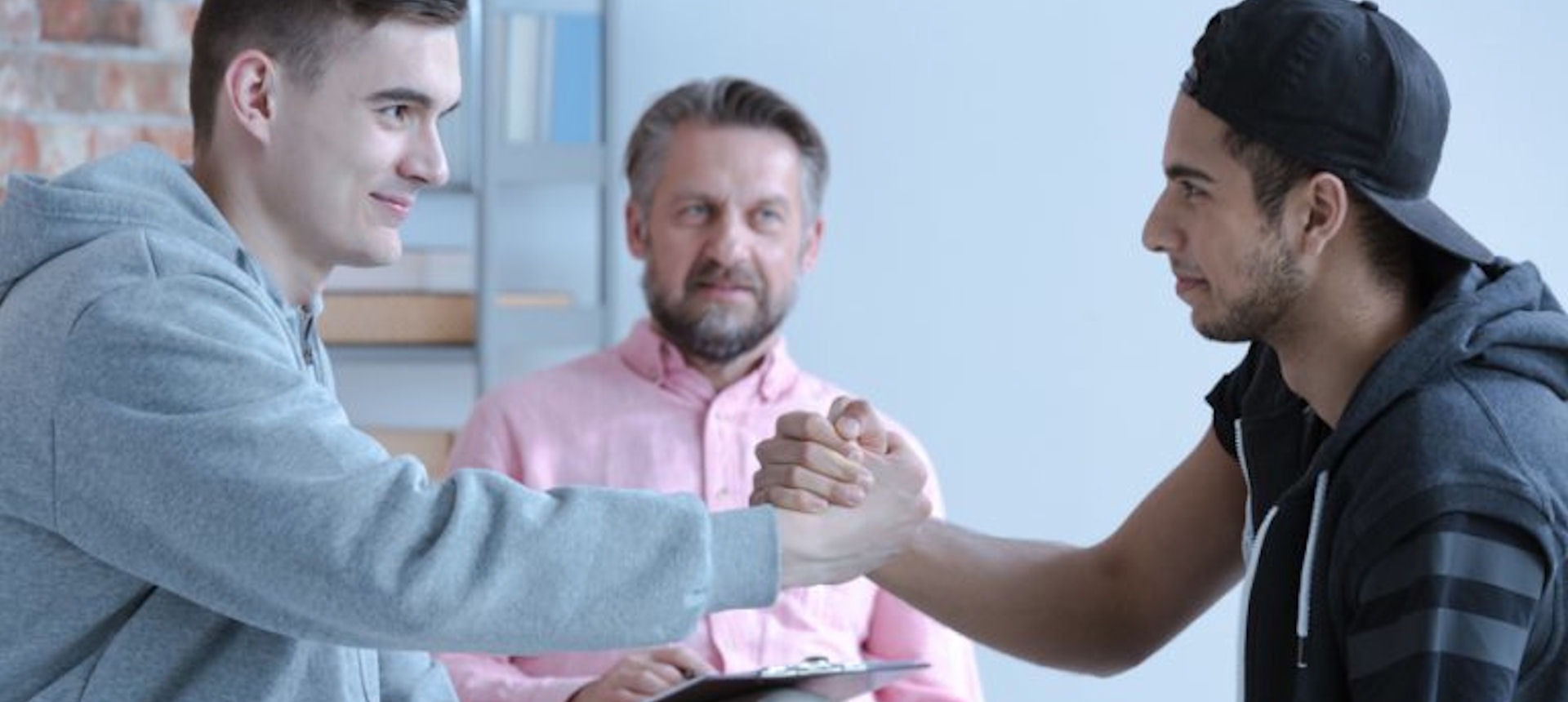 two men shaking hands in therapy