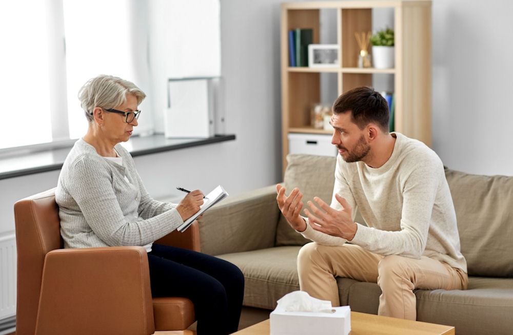 an alcoholic man talking to his therapist during an individual therapy session